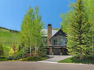 Experience luxury mountain living in this stunning home, nestled against a backdrop of rolling green hills and mature trees.