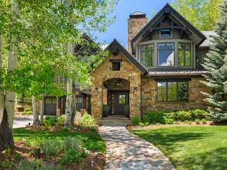 Discover this stunning mountain home featuring a grand stone entryway and a charming covered porch.