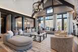 Experience luxurious mountain living in this stunning great room, featuring a grand sectional sofa and plush armchairs perfect for gathering.