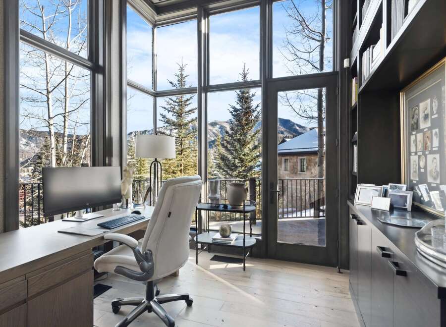 Experience breathtaking mountain views from this stunning home office, featuring expansive windows that flood the space with natural light.