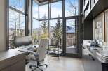 Experience breathtaking mountain views from this stunning home office, featuring expansive windows that flood the space with natural light.
