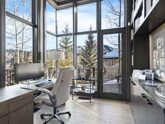 Experience breathtaking mountain views from this stunning home office, featuring expansive windows that flood the space with natural light.