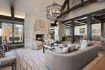 Experience luxury mountain living in this stunning great room, featuring a grand stone fireplace and soaring beamed ceilings.