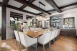 Experience elegant dining in this sophisticated space, featuring a grand wooden dining table surrounded by plush upholstered chairs.