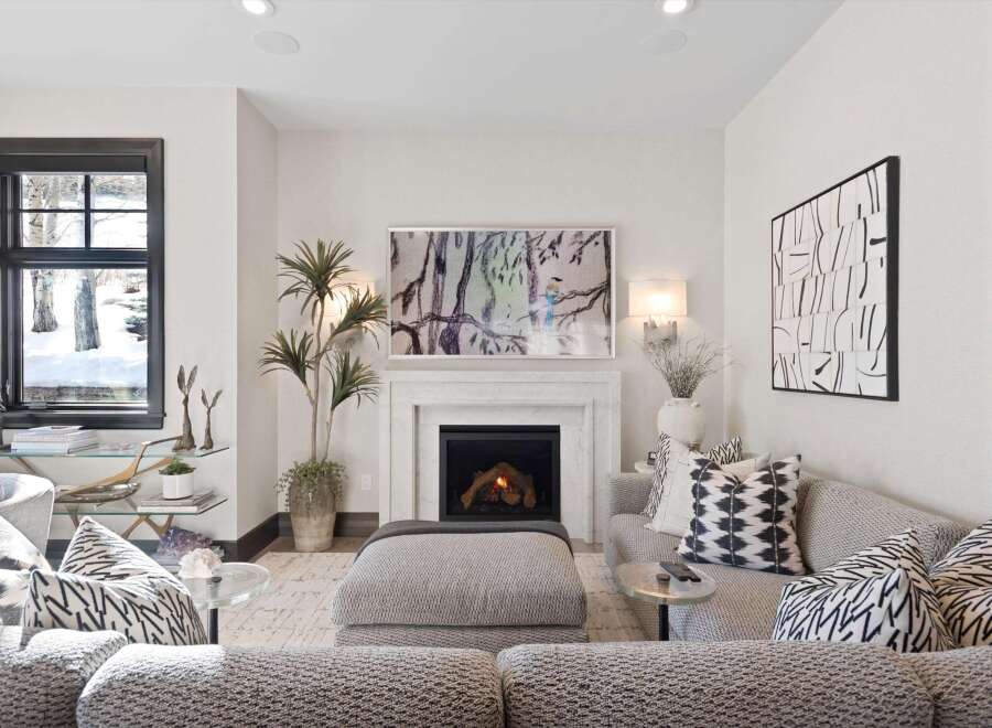 Cozy up by the fireplace in this inviting living room, featuring a marble surround and a vibrant abstract artwork.