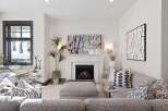 Cozy up by the fireplace in this inviting living room, featuring a marble surround and a vibrant abstract artwork.