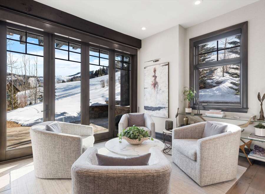 Experience luxurious mountain living in this stunning living area, featuring plush, modern seating arranged around a chic marble coffee table.