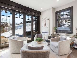 Experience luxurious mountain living in this stunning living area, featuring plush, modern seating arranged around a chic marble coffee table.