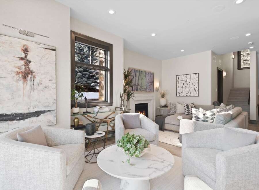 Experience luxury living in this stunning modern living room, featuring a cozy fireplace and elegant artwork.