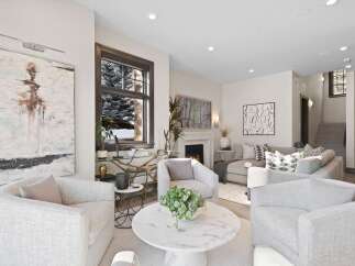 Experience luxury living in this stunning modern living room, featuring a cozy fireplace and elegant artwork.