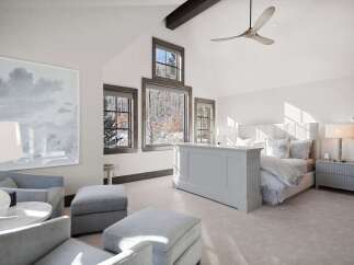 Experience luxury mountain living in this stunning bedroom featuring a vaulted ceiling with a modern fan and exposed beams.