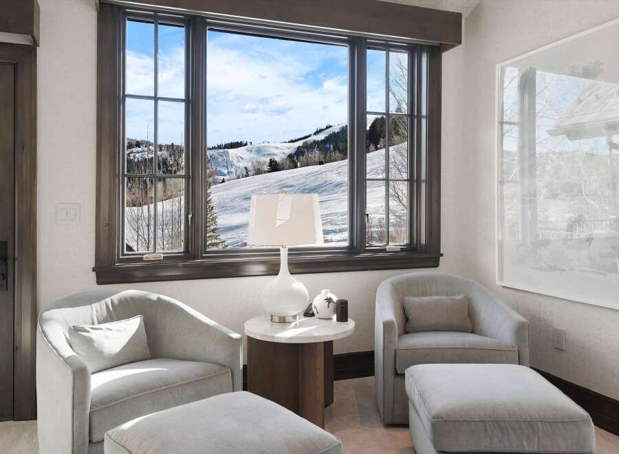 Enjoy breathtaking mountain views from this cozy seating area, perfect for relaxing after a day on the slopes.