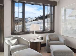 Enjoy breathtaking mountain views from this cozy seating area, perfect for relaxing after a day on the slopes.