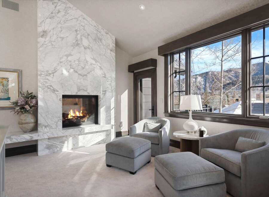Experience luxury living with this stunning living room featuring a grand marble fireplace, perfect for cozy evenings.