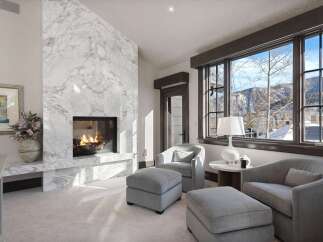 Experience luxury living with this stunning living room featuring a grand marble fireplace, perfect for cozy evenings.