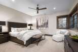 Experience luxury mountain living in this stunning bedroom, featuring a king-sized bed with crisp white linens and a stylish upholstered headboard.