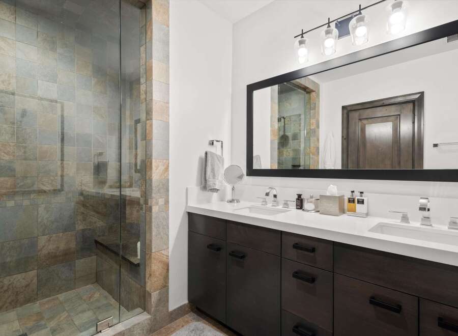 Experience luxury in this stunning bathroom featuring a spacious walk-in shower with elegant stone tilework.