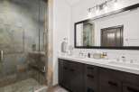 Experience luxury in this stunning bathroom featuring a spacious walk-in shower with elegant stone tilework.