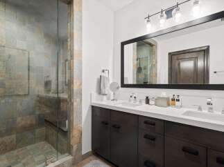 Experience luxury in this stunning bathroom featuring a spacious walk-in shower with elegant stone tilework.