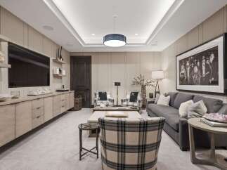 Experience luxury living in this sophisticated media room, featuring a large wall-mounted television and a sleek, modern entertainment console.