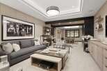 Experience ultimate relaxation and entertainment in this sophisticated game room, featuring a stylish gray sectional sofa and a striking black and white framed artwork.