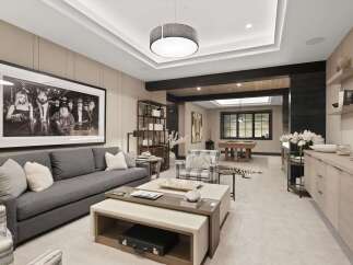 Experience ultimate relaxation and entertainment in this sophisticated game room, featuring a stylish gray sectional sofa and a striking black and white framed artwork.