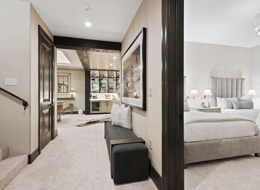 Step into a luxurious lower level featuring a stylish bar area with ample shelving and a wine fridge, perfect for entertaining.