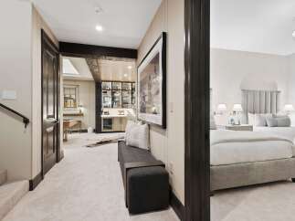 Step into a luxurious lower level featuring a stylish bar area with ample shelving and a wine fridge, perfect for entertaining.