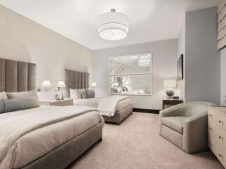 Experience luxurious comfort in this elegantly appointed bedroom featuring two plush queen beds with sophisticated upholstered headboards.