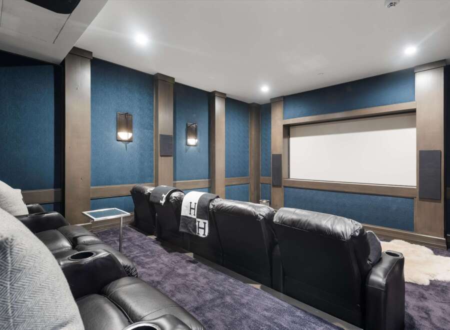 Experience cinematic luxury in this state-of-the-art home theater, featuring plush reclining leather seats with built-in cup holders for ultimate comfort.