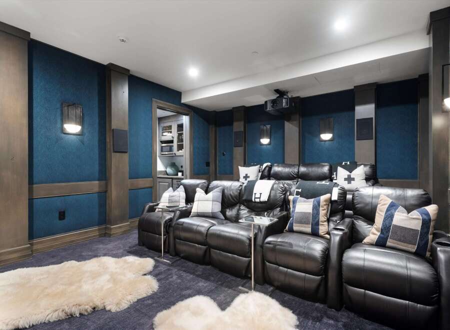 Experience cinematic bliss in this luxurious home theater, featuring plush leather recliners and a state-of-the-art projector.