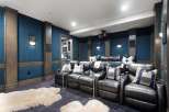 Experience cinematic bliss in this luxurious home theater, featuring plush leather recliners and a state-of-the-art projector.