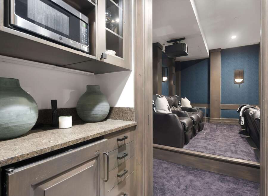 Experience cinematic bliss in this home theater, featuring plush leather recliners and a projector for an immersive viewing experience.