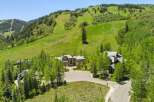 Experience luxury mountain living in this stunning estate, nestled against a backdrop of lush green ski slopes and mature trees.