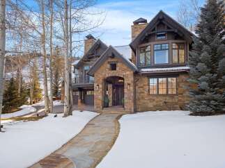 Experience luxury mountain living in this stunning stone and timber home, nestled amidst a winter wonderland.