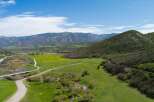 Discover this stunning property featuring rolling green hills, a vibrant yellow wildflower meadow, and a serene creek.