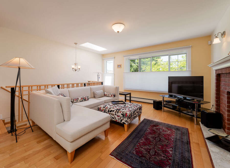 Step into this inviting living room, featuring a spacious sectional sofa and a decorative ottoman, perfect for relaxing or entertaining.