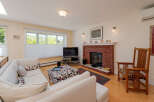 Step into this inviting living room, featuring a cozy brick fireplace and a large sectional sofa perfect for relaxation.