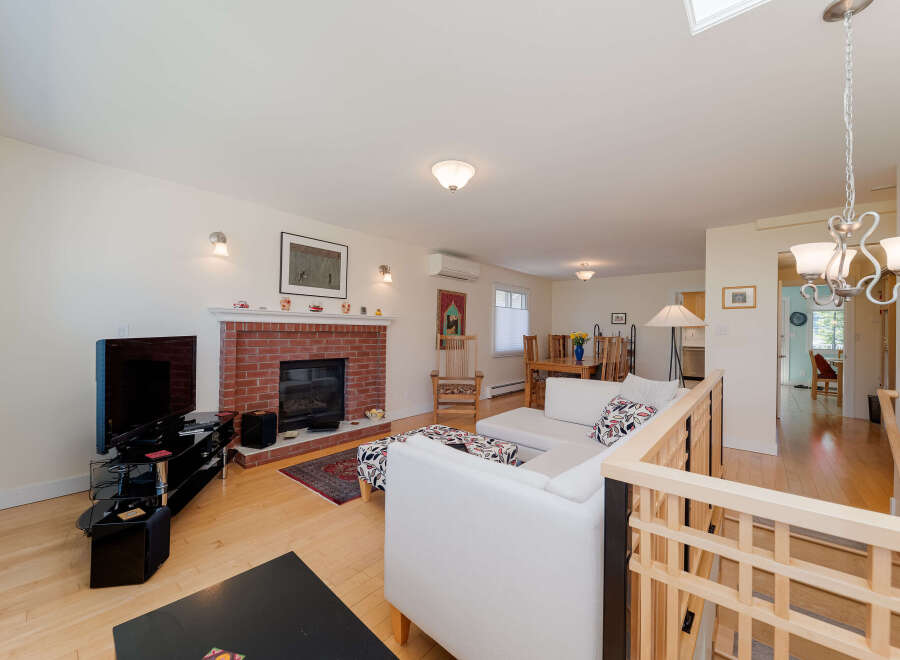 Step into this inviting living space featuring a cozy brick fireplace and a comfortable sectional sofa perfect for gatherings.