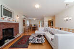 Experience comfortable living in this inviting space, featuring a cozy brick fireplace and a spacious sectional sofa adorned with decorative pillows.