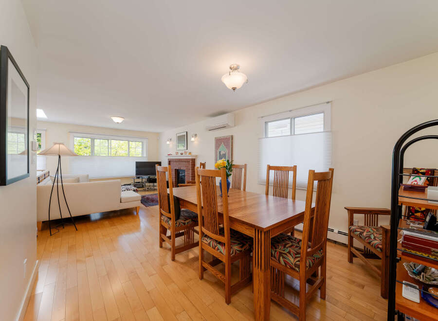 This spacious open-concept living and dining area features a beautiful wooden dining set perfect for family meals.