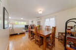This spacious open-concept living and dining area features a beautiful wooden dining set perfect for family meals.