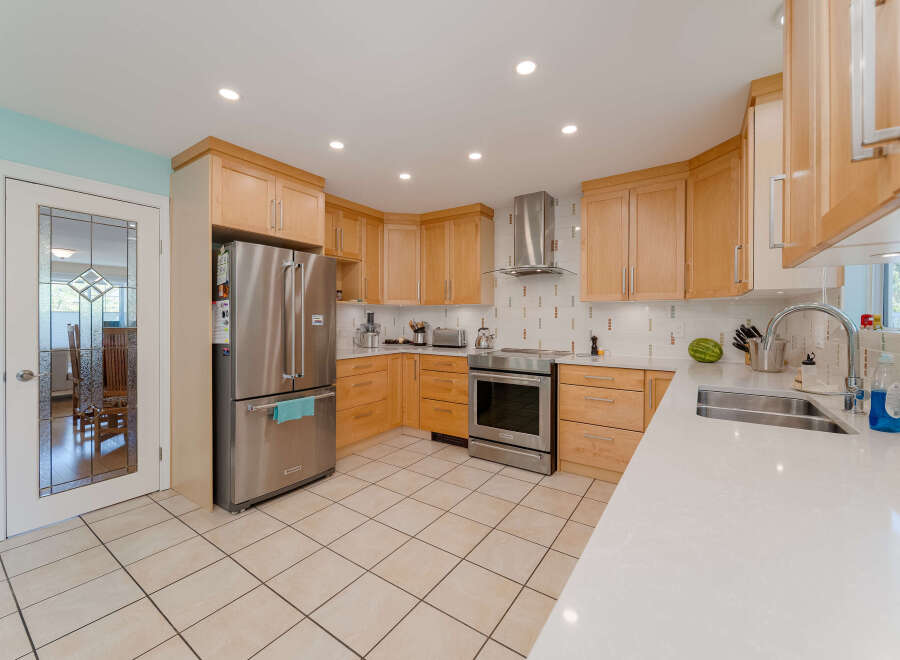 Discover this beautifully updated kitchen featuring sleek stainless steel appliances, including a French door refrigerator and a modern range.