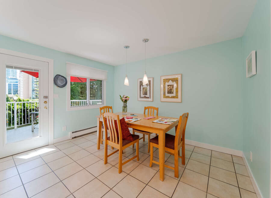 Bright and airy dining area featuring a light wood table with four chairs, perfect for intimate meals.