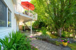 Enjoy outdoor living with this charming backyard featuring a spacious deck perfect for entertaining and a lower patio area ideal for relaxing.