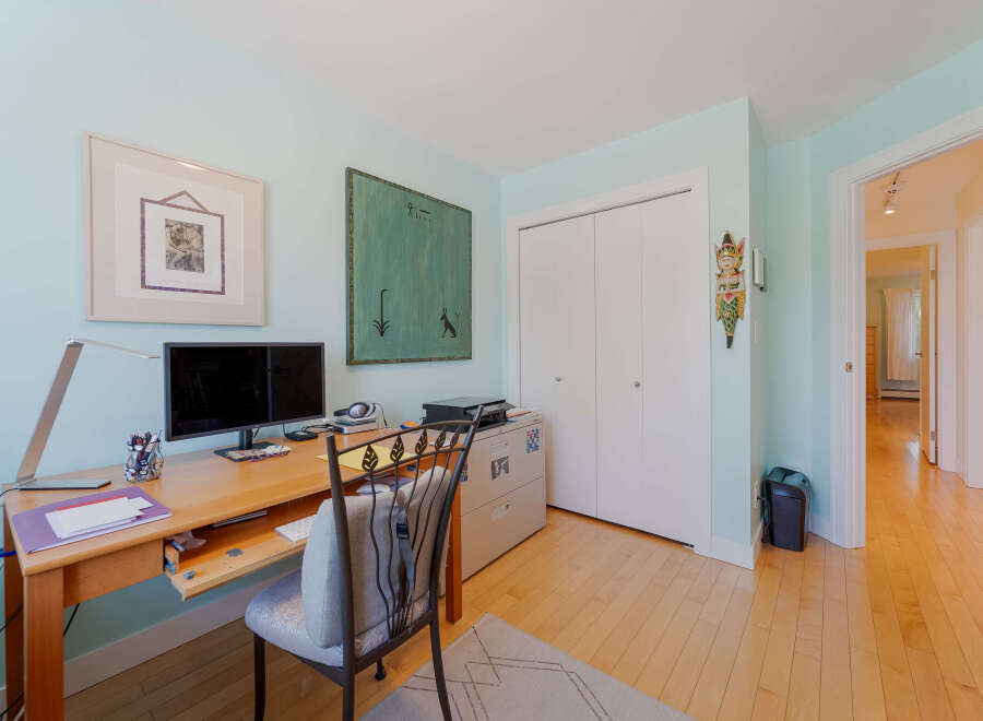 This home office features a spacious wooden desk equipped with a dual monitor setup, perfect for productivity.