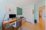 This home office features a spacious wooden desk equipped with a dual monitor setup, perfect for productivity.
