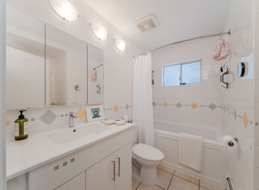 This bright and clean bathroom features a modern vanity with ample storage and a sleek faucet.
