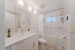 This bright and clean bathroom features a modern vanity with ample storage and a sleek faucet.