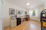 This home office features a spacious desk with a laptop and printer, perfect for productivity.